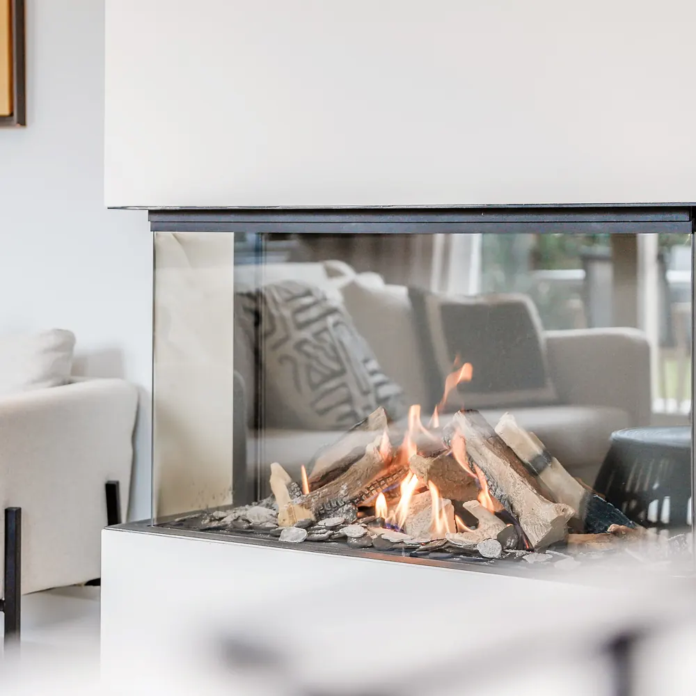Moderne peis med glass i en lys stue